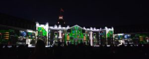 A photo of a town hall with a series of computer components projected onto it as part of a light show